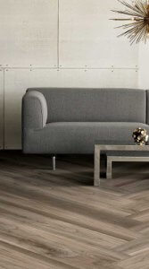 Grey couch and modular coffee table on a herringbone style floor