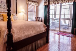 bedroom with four poster bed and hardwood floor