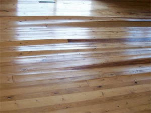 A serverely damaged hardwood floor with cupping