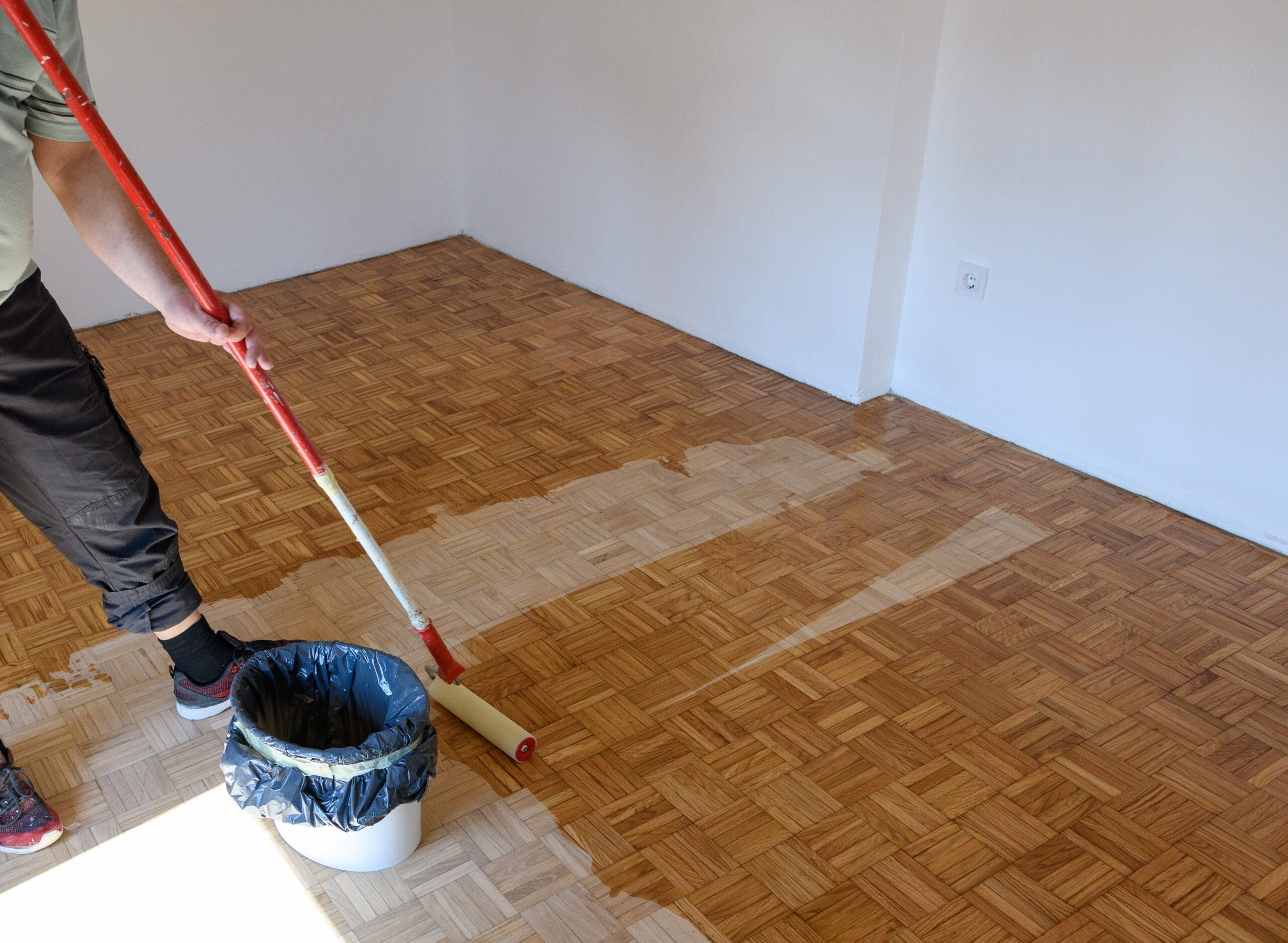 man-applying-lacquer-finish-on-oak-hardwood-floor